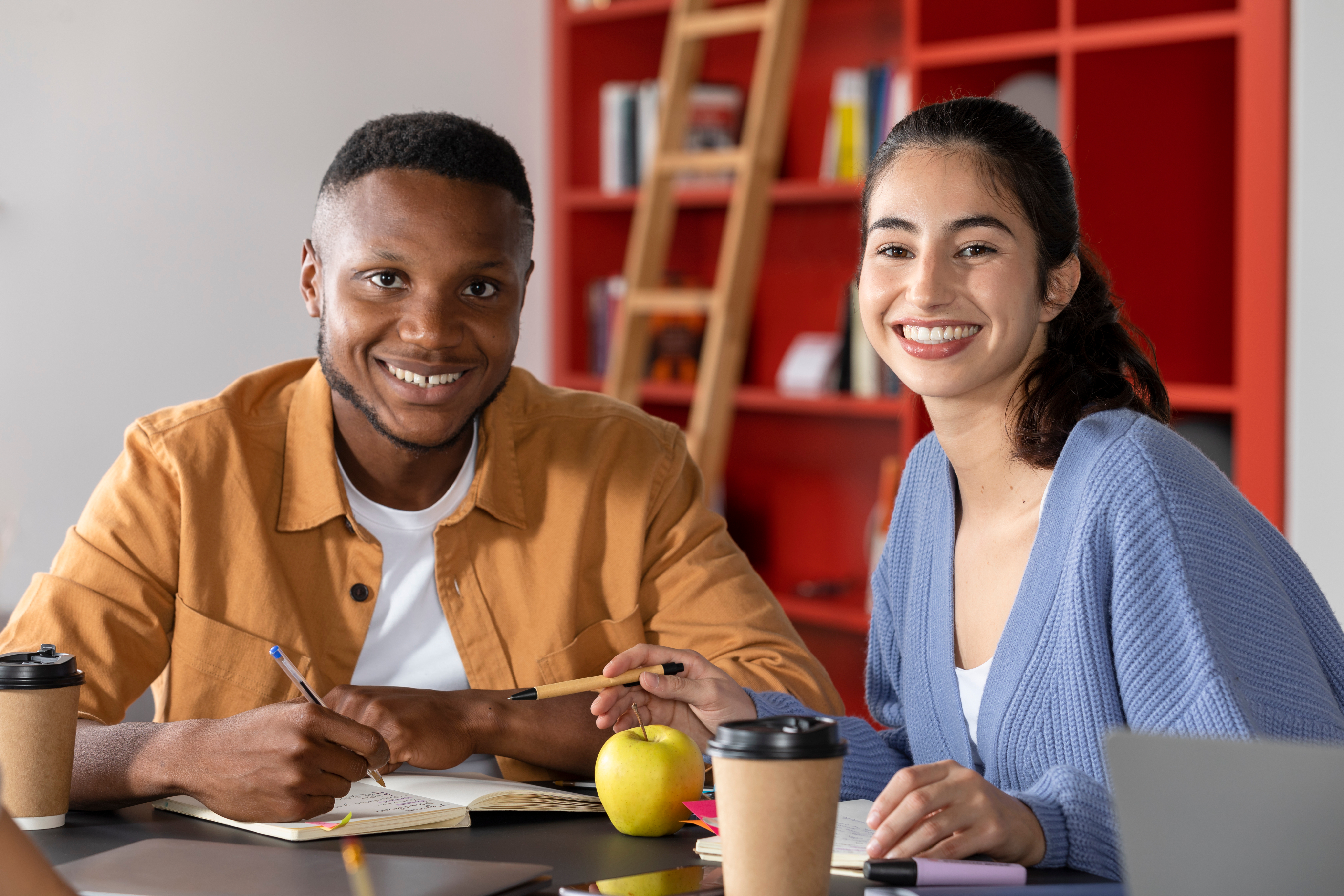 Smiling male tutor and female student working together at a table